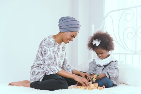 Beautiful African American Mother Playing with Adorable Baby Boy at Home on Living Room Floor....
