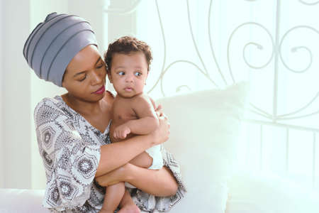 African mother raising a happy baby in the houseの写真素材