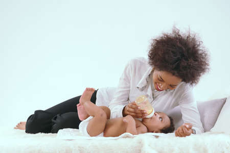 Black mother is having fun in her bedroom in the house.の写真素材