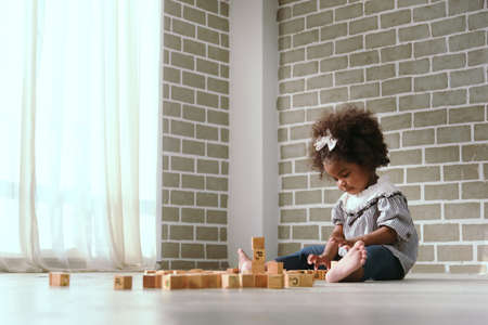 Young black girl is having fun playing and learning to strengthen her cognitive skills at home.の写真素材