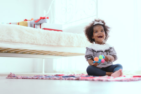 Young girls of color play in the bedroom of the house where the flag-patterned carpet sits.の写真素材