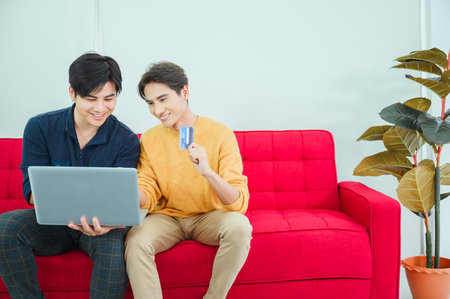 LGBQ concept of sexual diversity Asian gay couple using laptop to shop onlineの写真素材