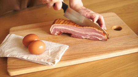 Preparing breakfast with bacon and eggsの写真素材