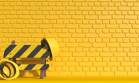 Yellow construction helmet and road barrier sign is on a background of a yellow brick wall....
