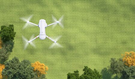 Drone flying over the green lawn covered with grass. Quadrocopter over a clearing with trees. Top view. Illustration with copy space. 3D rendering.の写真素材