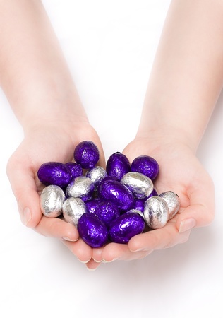 Pair of hands holding purple and silver Easter eggsの写真素材