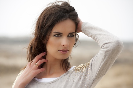 Portrait of a beautiful young woman with brown eyes in the dunesの写真素材