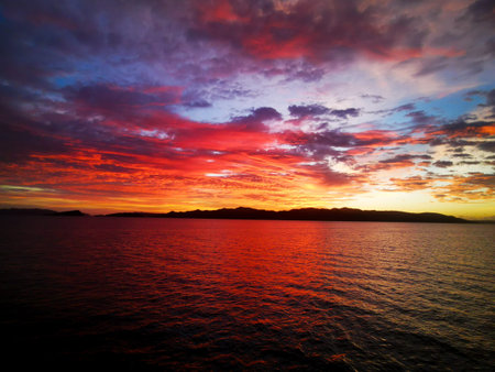 Stunning sunset over islands with reflection on he se in the foreground