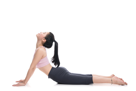 A studio portrait of a twenties Asian woman showing flexible and amazing behaviorの写真素材