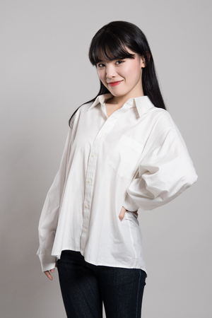 Studio portrait of twenties Asian woman in a dignified and happy smileの写真素材
