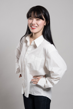Studio portrait of twenties Asian woman in a dignified and happy smileの写真素材