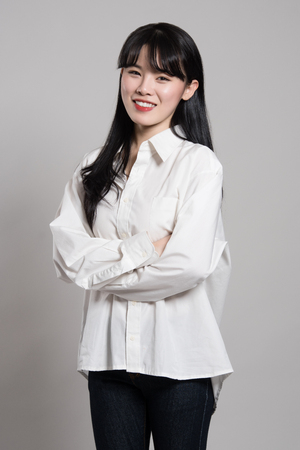 Studio portrait of twenties Asian woman in a dignified and happy smileの写真素材
