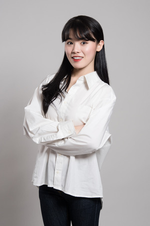 Studio portrait of twenties Asian woman in a dignified and happy smileの写真素材