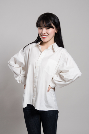 Studio portrait of twenties Asian woman in a dignified and happy smileの写真素材