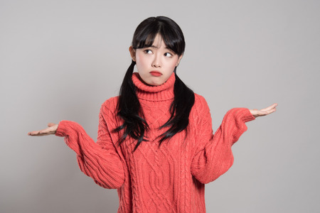 Studio portrait of 20 year old female Asian woman with both hands in absurd situationの写真素材