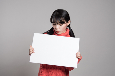 Studio portrait of 20 Asian women surprised holding billboardsの写真素材