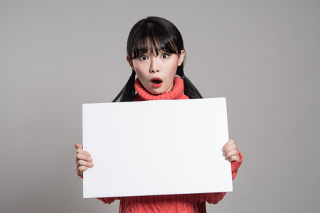 Studio portrait of 20 Asian women surprised holding billboardsの写真素材