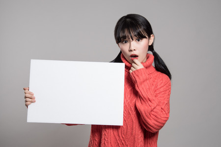 Studio portrait of 20 Asian women surprised holding billboardsの写真素材