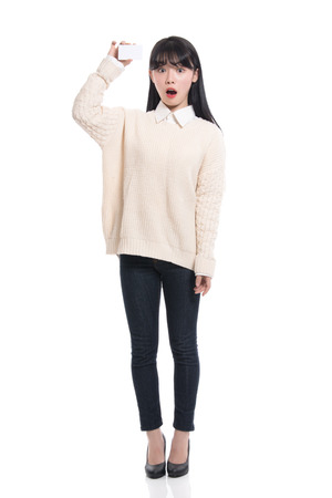 Studio portrait of twenties Asian woman happily having a cardの写真素材