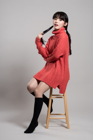 Studio fashion portrait of a happy and confident twenties Asian womanの写真素材