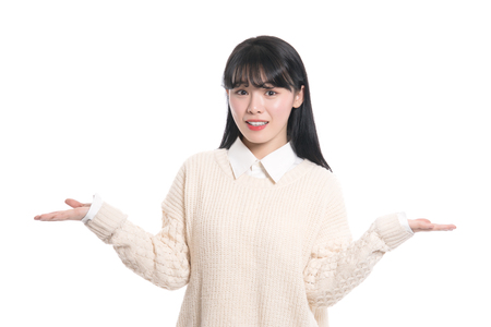 A studio portrait of a twenties Asian woman pointing at something and confidently introducingの写真素材