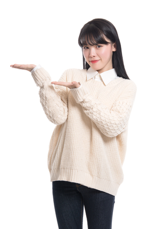 A studio portrait of a twenties Asian woman pointing at something and confidently introducingの写真素材