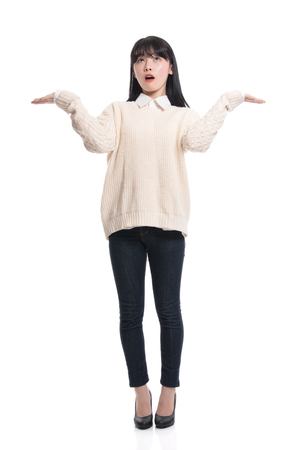 A studio portrait of a twenties Asian woman pointing at something and confidently introducingの写真素材
