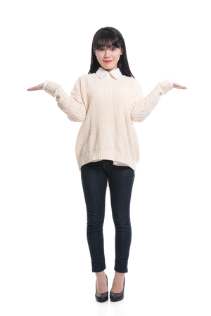 A studio portrait of a twenties Asian woman pointing at something and confidently introducingの写真素材