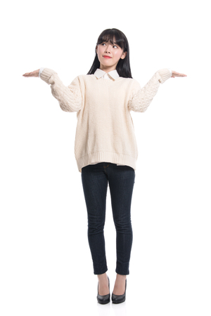 A studio portrait of a twenties Asian woman pointing at something and confidently introducingの写真素材