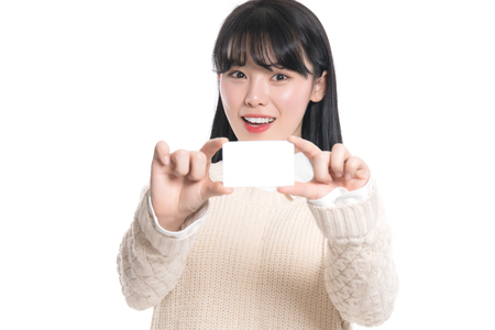 Studio portrait of twenties Asian woman happily having a cardの写真素材