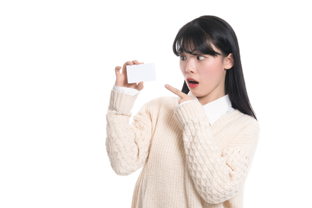 Asian female studio portrait surprised looking at cardの写真素材