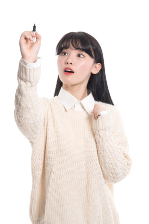 Studio portrait of twenties Asian woman writing something with a penの写真素材