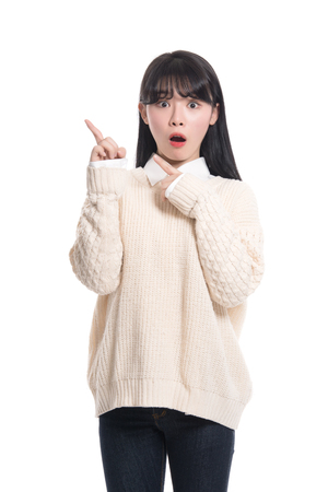 A studio portrait of a twenties Asian woman pointing at somethingの写真素材