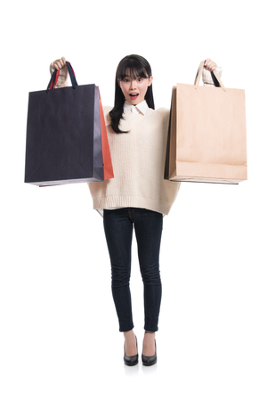 Studio portrait of twenties Asian woman happily shoppingの写真素材