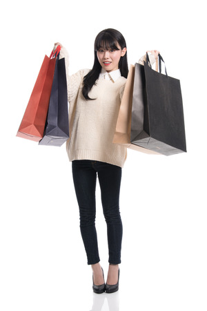 Studio portrait of twenties Asian woman happily shoppingの写真素材