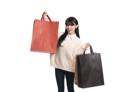Studio portrait of twenties Asian woman happily shoppingの写真素材
