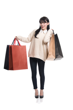 Studio portrait of twenties Asian woman happily shoppingの写真素材