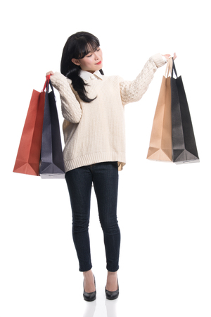 Studio portrait of twenties Asian woman happily shoppingの写真素材