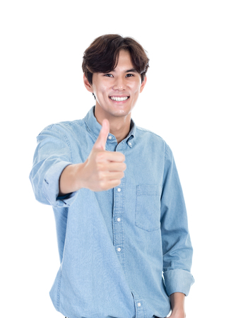 Portrait of an Asian young man holding a thumb upの写真素材