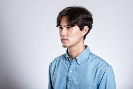 Studio portrait of an Asian man holding a cardの写真素材