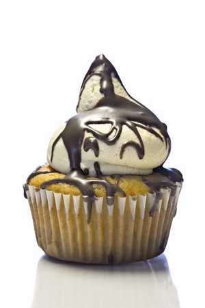 Beautiful yellow cupcake with buttercream and chocolate frosting on white backgroundの写真素材
