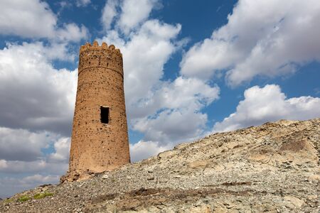 One of many old watchtowers on prominent location on the hills surrounding Al Mudairib in Omanの写真素材