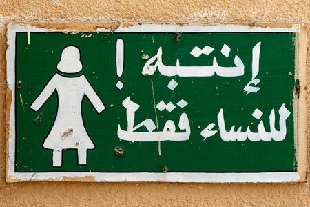Sign on a wall in old town of Al Mudairib in Oman allowing entrance for women onlyの写真素材