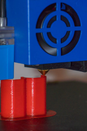 3d printer printing red and blue plastic parts on a 3D printer