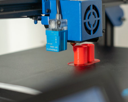 3D printer printing red and blue plastic parts. 3D printing