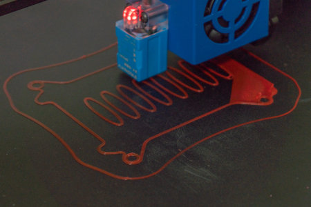 Close-up of a 3D printer printed with red light.