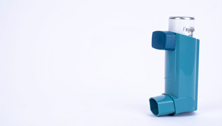 Isolated blue asthma inhaler device on white surface, healthcare and medical concept