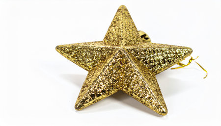 A golden star shaped decoration with glittering texture on a white background