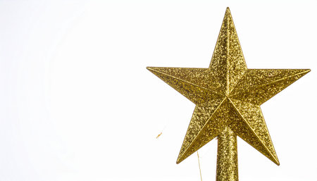 Golden star decoration on a white background, Christmas tree topper, festive holiday season.