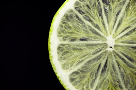See through slice of lime fruit on blackの写真素材